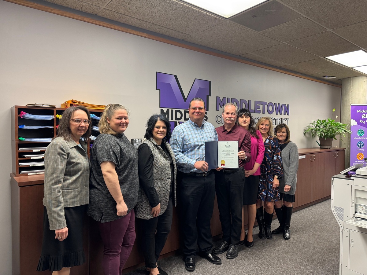 Members of the MCSD finance team stand with representative holding award.